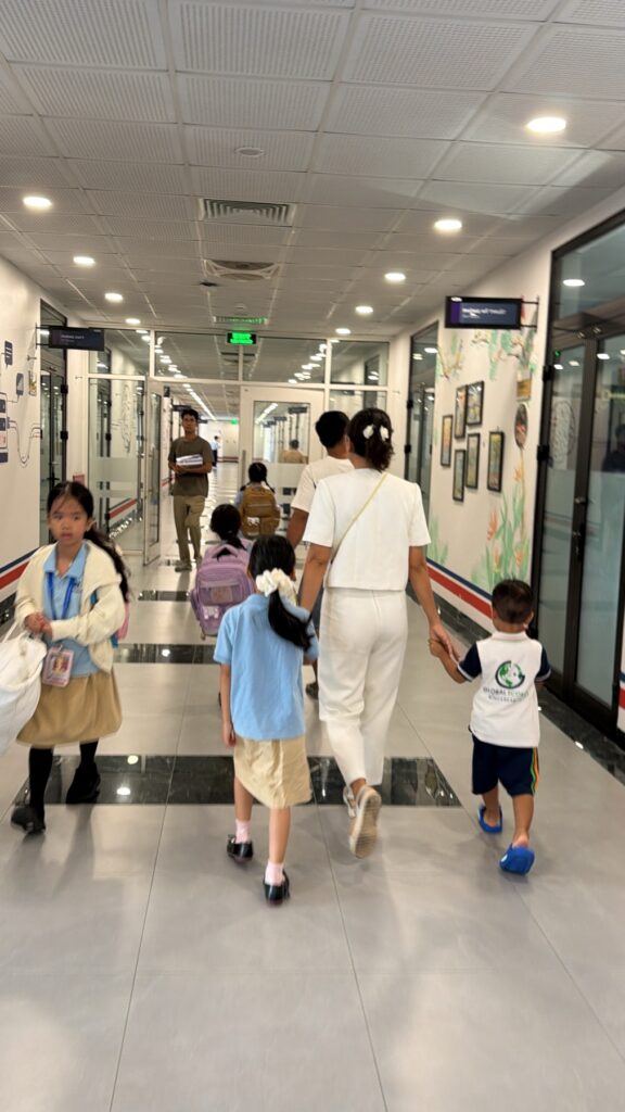 Mẹ dắt Chu Chu và LeO đi dọc hành lang trường Vinschool trong ngày đầu năm học