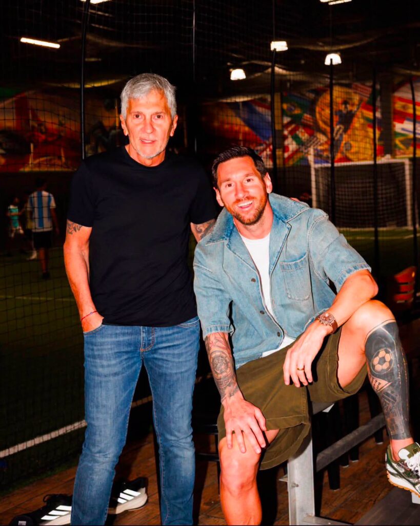 Lionel Messi ngồi bên cạnh ba mình, ông Jorge Messi, trong một sân bóng trong nhà